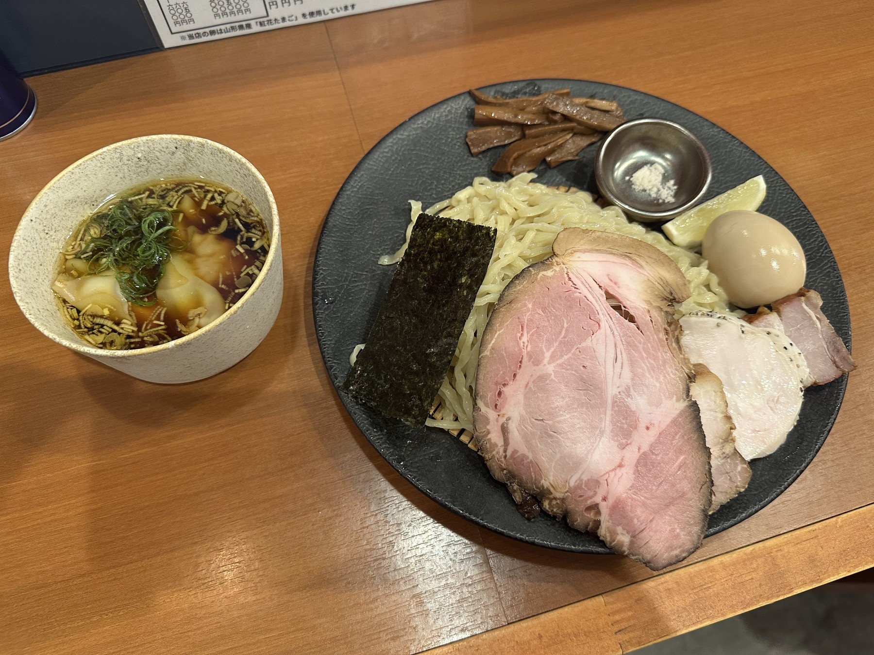 別角度から見た淡麗特製つけ麺。手もみ麺と複数のチャーシュー、味玉、メンマ、海苔、レモン、塩